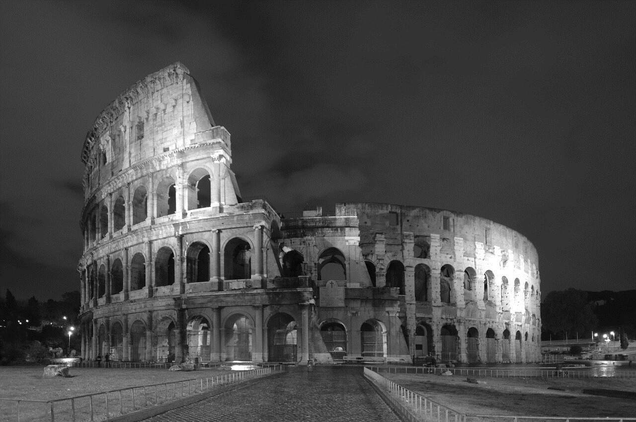 The Colosseum illuminated at night in a black-and-white photograph