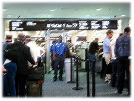 Travellers and staff at an airport security screening checkpoint