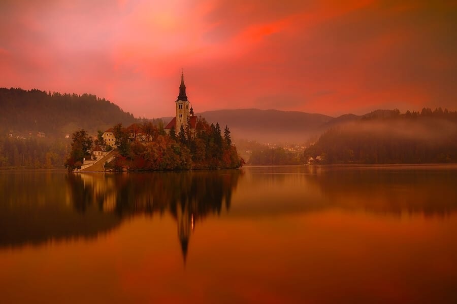 Lake Bled’s island church reflected in the water beneath a glowing evening sky