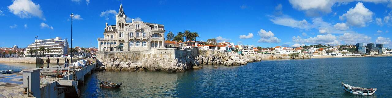 Cascais waterfront with boats, a small beach and the Seixas palace