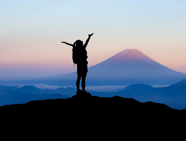Backpacker silhouetted against a mountain landscape