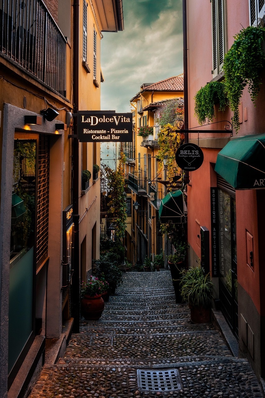 A Southern European old town street with warm light and café tables