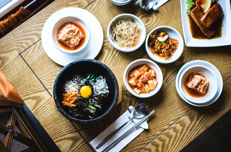 Korean table setting with banchan and grilled dishes