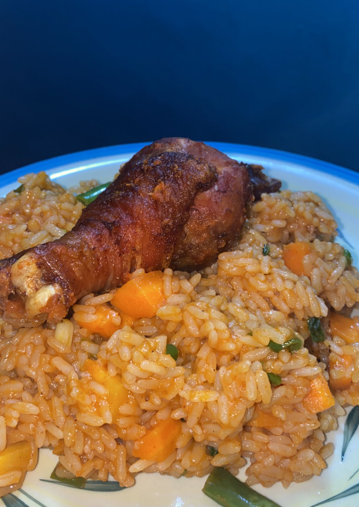 Nigerian jollof rice plated with side dishes