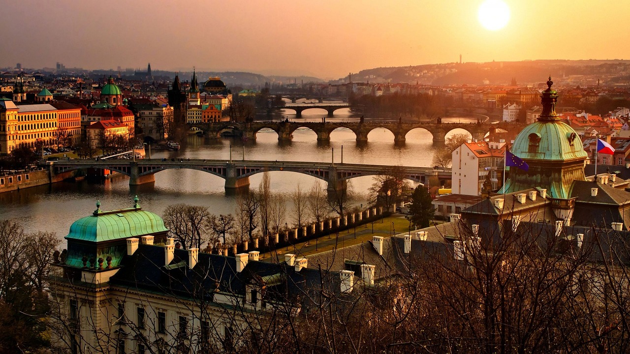 A riverside Eastern European city at golden hour with bridges and historic buildings