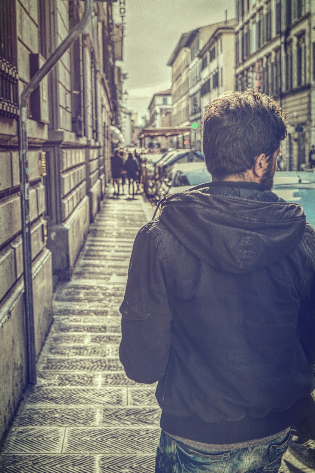 Traveller walking through an old sunlit street, reflecting on the inspiration to travel