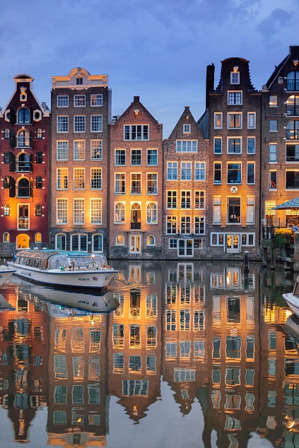 Amsterdam canal houses reflected in the water at dusk
