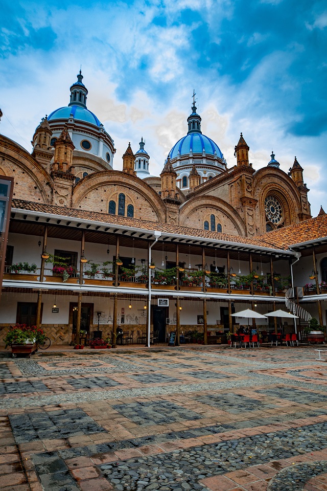 Blue cathedral domes rising above a courtyard in Ecuador
