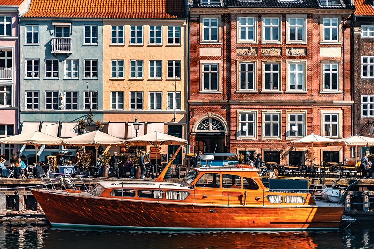 Colorful Nyhavn buildings and a wooden boat on Copenhagen’s waterfront