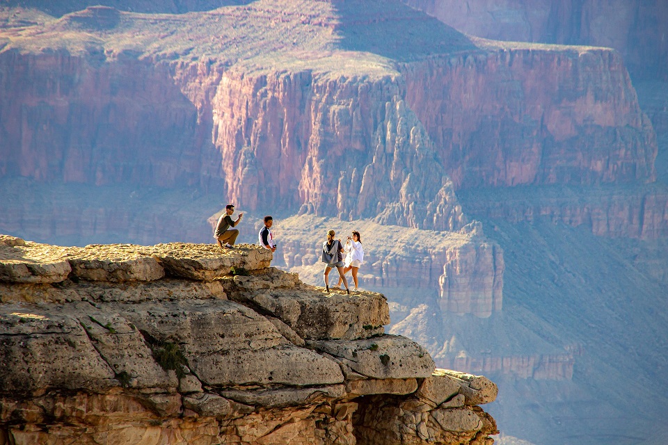 Visitors overlooking a vast layered canyon