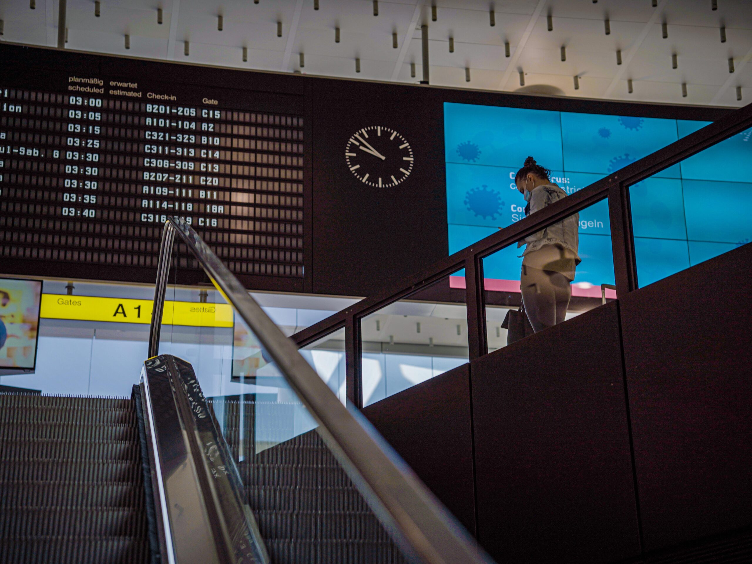 Traveller at an airport beneath the departure board