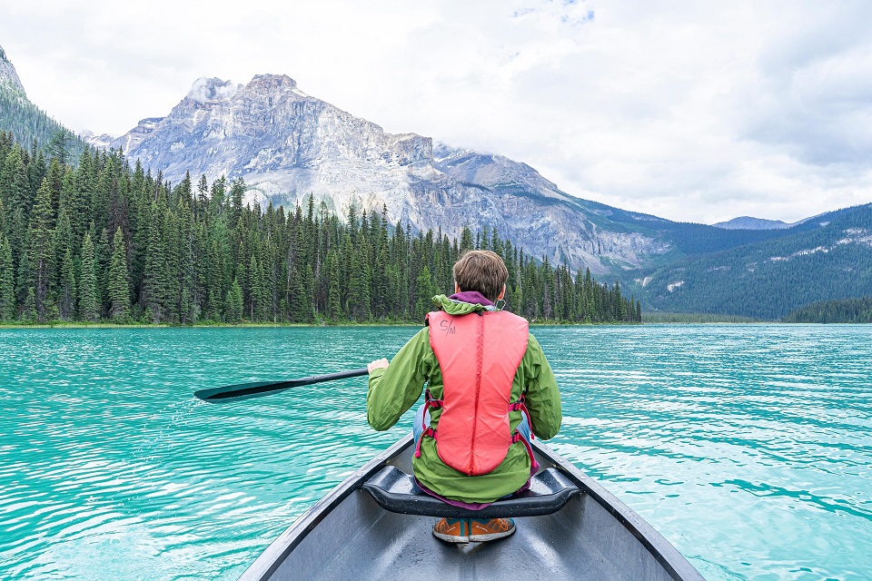 Canoe on a turquoise lake beneath mountains in Yoho National Park, British Columbia