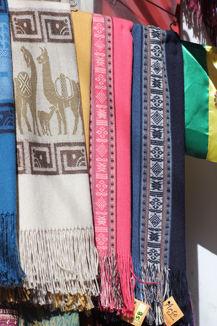 Colourful Bolivian woven scarves with llama motifs, geometric patterns and fringed ends
