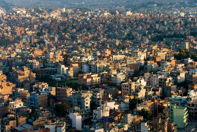 Dense buildings across Kathmandu in warm sunlight