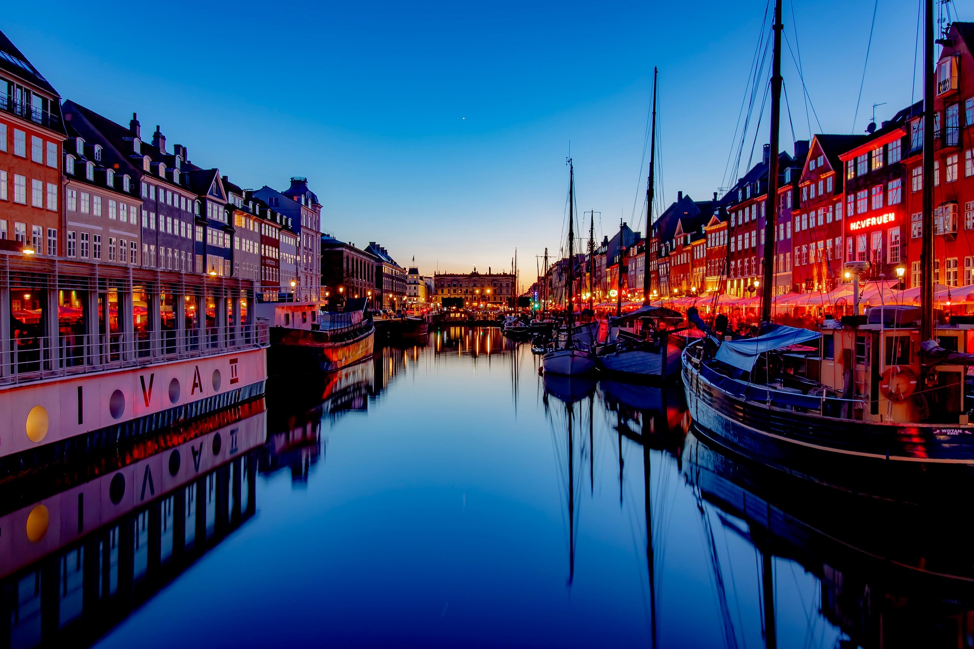 Boats and illuminated waterfront buildings at Nyhavn at dusk
