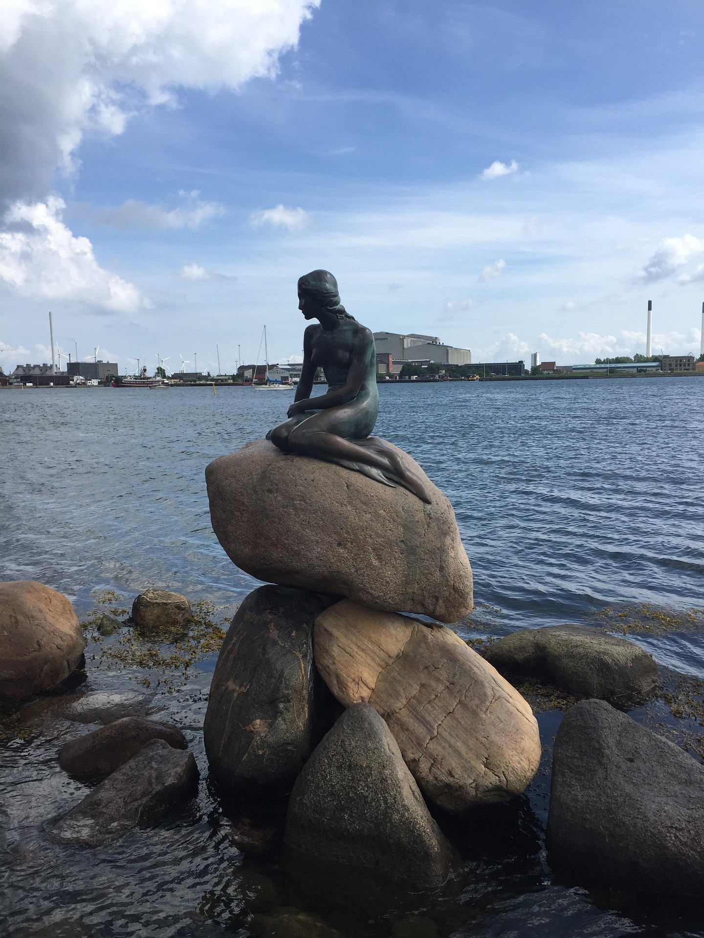 The Little Mermaid statue on rocks beside Copenhagen’s harbor