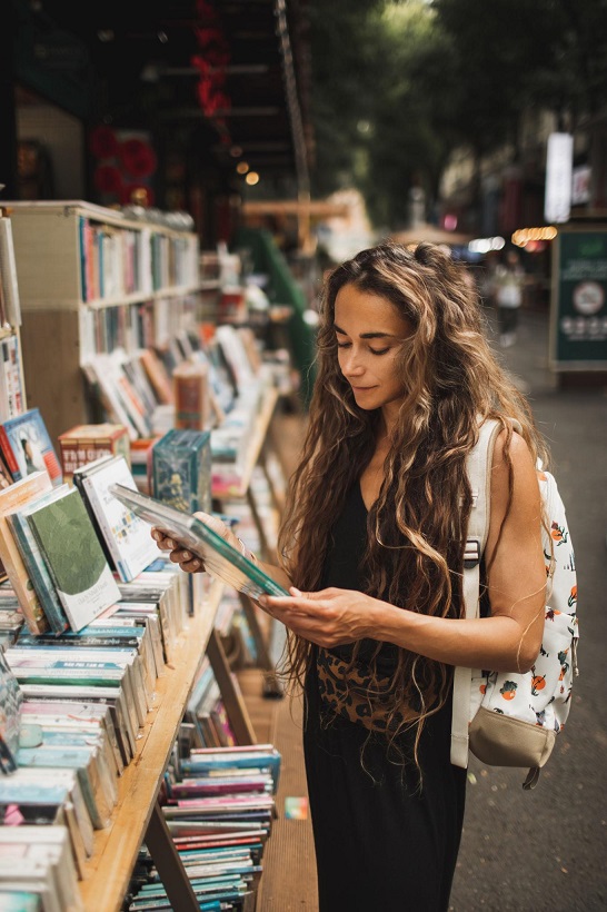 Woman browsing books at an outdoor bookstall